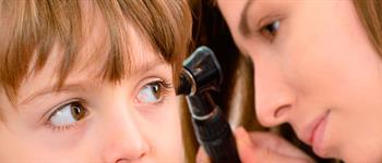 ClinicaAlemana_Articulos_salud_oidos_tapados Doctor revisando oídos tapados en niño Clínica Alemana