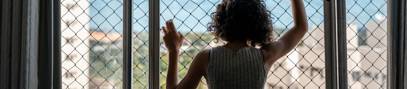 como-elegir-unamalla-de-seguridad-para-ventanal Mujer-mirando-malla-de-seguridad