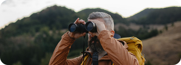 viaja protegido m persona con binoculares observando el paisaje