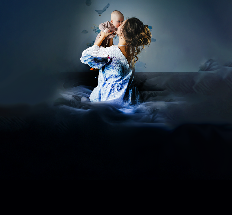 Fotografía de una madre con su bebé en fondo oscuro, con la tranquilidad que entregan los chequeos preventivos de Clínica Alemana.