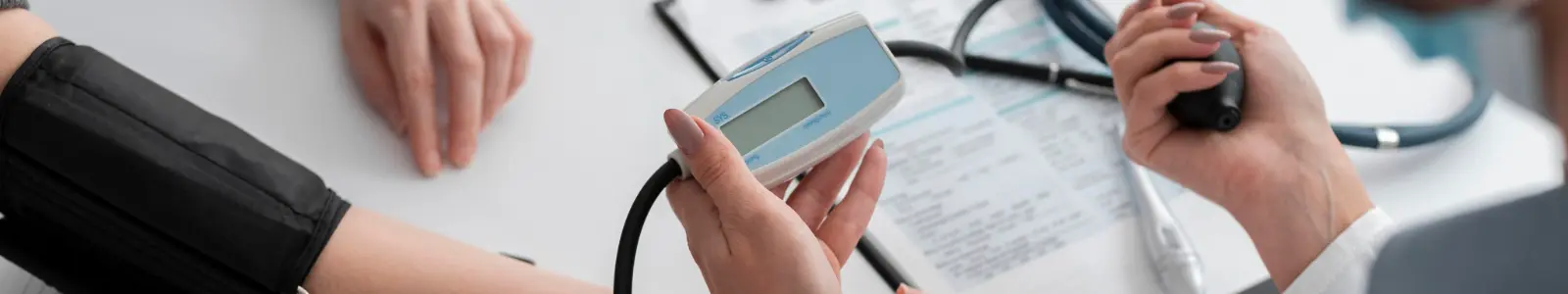 Examen de presión arterial en consulta médica, parte de los chequeos preventivos recomendados después de los 40 años.