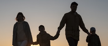 Familia caminando al atardecer, representando la protección y bienestar que ofrecen los seguros de salud.