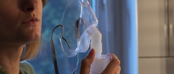 Mujer utilizando un nebulizador en casa, representando los riesgos de intoxicaciones por monóxido de carbono y la importancia de contar con un seguro accidentes Alemana Seguro.